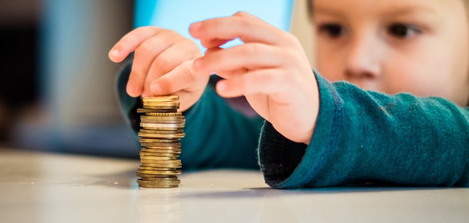 Close up boys hand making stucks of coins on the table